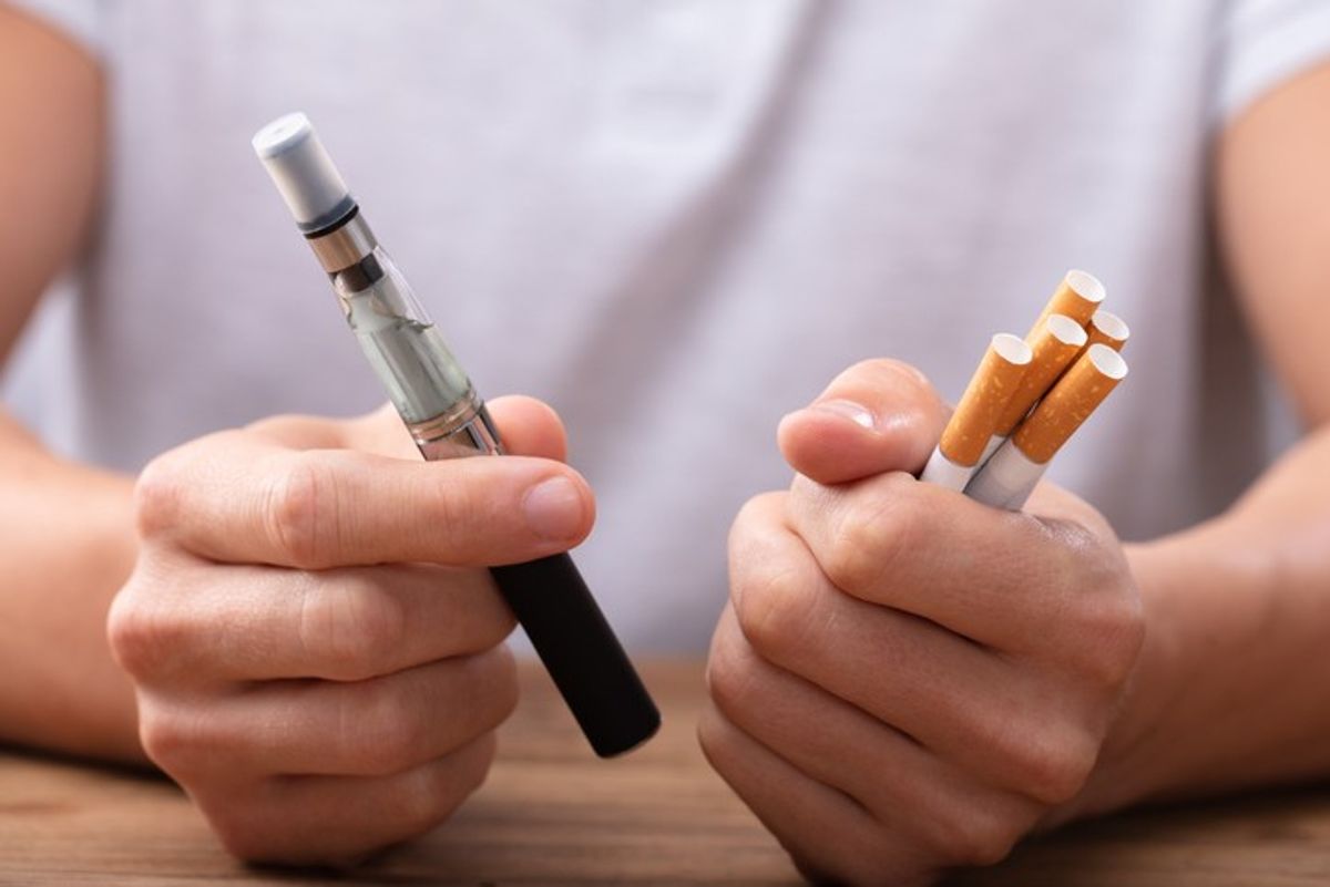 A person smoking a cigarette as vaping regulations tighten in the UK