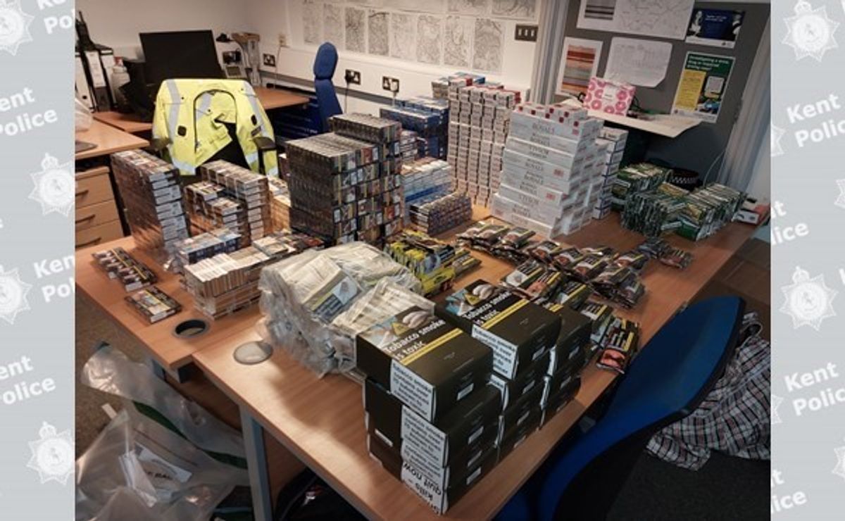 Kent Police officer inspecting 20kg of illicit tobacco at Upper Stone Street shop, revealing illicit tobacco dangers in Maidstone.