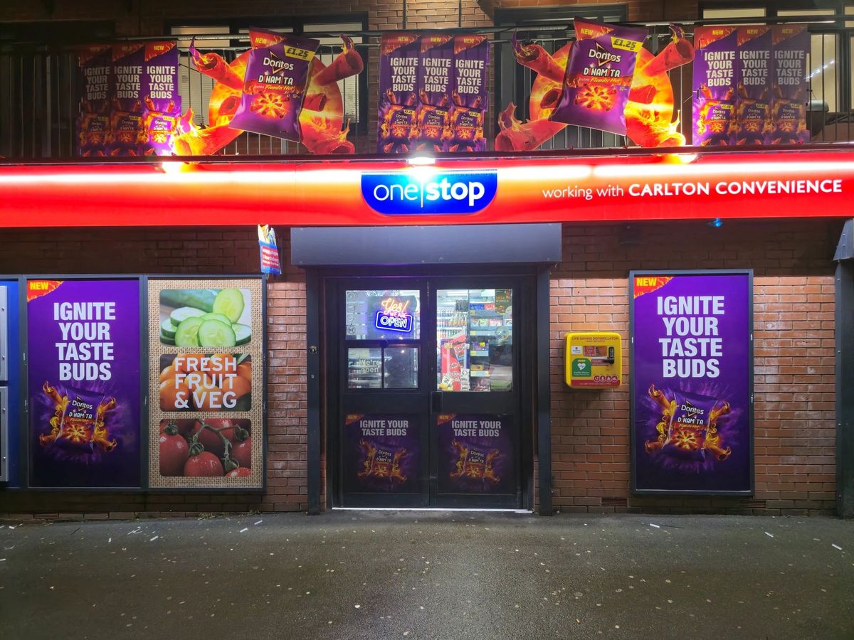 One Stop Carlton storefront in Manchester with Doritos Dinamita activation, featuring purple window vinyls and fiery branding